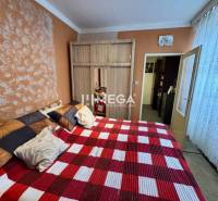 Na predaj 2 izbový byt  na Sokolovskej ulici v meste Humenné - Spálňa v 2-izbovom byte s červeno-bielou károvanou prikrývkou a vstavanou skriňou.