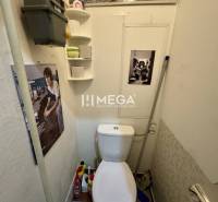 Na predaj 2 izbový byt  na Sokolovskej ulici v meste Humenné - Toaleta s dekoráciami v 2-izbovom byte. Podlaha s dreveným dekorom, poličky, potrubie.