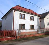 Na predaj rodinný dom na krásnom pozemku v obci Kamienka (Humenné)! - Rodinný dom na ulici v Kamienke so sedlovou strechou a červeným plotom.