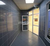 PRENÁJOM obchodného priestoru v OD LABOREC v meste Humenné - Chodba s modrými kachličkovými stenami vedúca do obchodných priestorov s presklenými dverami.