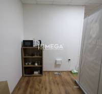 NA PRENÁJOM - obchodný priestor v OD Laborec, pešia zóna mesta Humenné - Interiér obchodných priestorov s policou, mikrovlnkou a podlahou s dreveným dekorom.