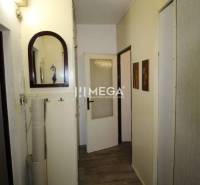 NA PRENÁJOM - Garsónka v pôvodnom stave na Sídlisku III v meste Humenn - Chodba v rekreačnom apartmáne s podlahou s dreveným dekorom, zrkadlom a dekoratívnym zrkadlom.