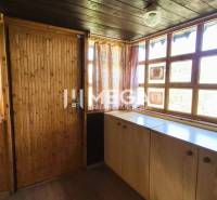 PREDAJ REKREAČNEJ CHATY NA DOMAŠI časť DOBRÁ - Interiér chaty s dreveným obkladom, veľkými oknami a farebnými závesmi.