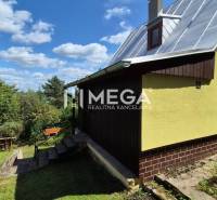 PREDAJ REKREAČNEJ CHATY NA DOMAŠI časť DOBRÁ - Chata na Vodárenskej ulici v Kvakovciach obklopená zeleňou, modrá obloha.