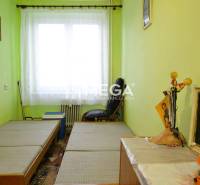 PREDAJ 3-izbového bytu v Medzilaborciach (TOP CENA) - Izba v 3-izbovom byte so zelenými stenami, dvoma posteľami a náboženskými obrazmi.
