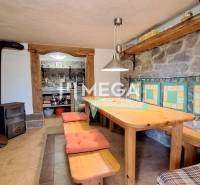 EXKLUZÍVNE NA PREDAJ Chata bez nutnosti investícií - VINNÉ - Kamenné steny a drevený stôl s lavicami v Chate. Podlaha s dreveným dekorom.