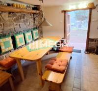 EXKLUZÍVNE NA PREDAJ Chata bez nutnosti investícií - VINNÉ - Interiér chaty s kamennou stenou a dreveným nábytkom, ladený do prírodných farieb.