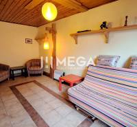 EXKLUZÍVNE NA PREDAJ Chata bez nutnosti investícií - VINNÉ - Izba v chate s keramickou dlažbou, farebným gaučom, kreslami a pieckou.