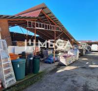 NA PREDAJ  Zabehnutá prevádzka v obci Kamenica nad Cirochou - Exteriér obchodných priestorov na Osloboditeľov 193, Kamenica nad Cirochou, rôznorodý stavebný materiál.