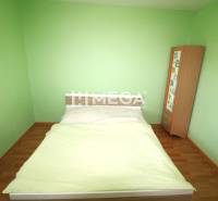 REZERVOVANÝ 3-izb. BYT – SÍDLISKO III, HUMENNÉ LABORECKÁ ul. - Zelená spálňa v 3-izbovom byte s podlahou s dreveným dekorom a nábytkom.