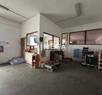 NA PREDAJ: OBJEKT VHODNÝ NA PODNIKANIE-SKLADOVANIE A SLUŽBY - Interiér skladov a hál s kanceláriou, schodmi, paletami a fľašami na vodu.