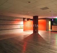 Veľký komerčný priestor 292 m2 priamo v centre mesta - Veľká miestnosť s drevenou podlahou a farebným osvetlením, vhodná na obchodné priestory.