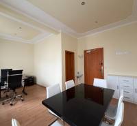 Prenájom kancelárie 33 m2 v centre Piešťan - Kancelárie s podlahou s dreveným dekorom, čiernym stolom a ergonomickými stoličkami.