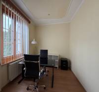 Prenájom kancelárie 33 m2 v centre Piešťan - Kancelárie s jedným stolom, stoličkou a svietidlom s dreveným dekorom podlahy.