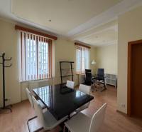 Prenájom kancelárie 33 m2 v centre Piešťan - Interiér kancelárie s podlahou s dreveným dekorom, vybavený stolmi a stoličkami.