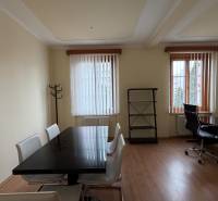 Prenájom kancelárie 33 m2 v centre Piešťan - Kancelárie s podlahou s dreveným dekorom, bielymi stenami a čiernym stolom.