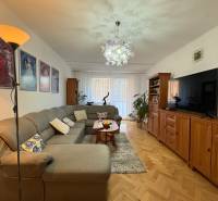 Na predaj: 4 izb.byt + BALKON + ŠATNIK + ŠPAJZA - Obývacia izba s pohovkou a podlahou s dreveným dekorom v 3-izbovom byte.