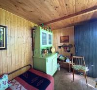 Na predaj: Ovocná záhrada v Leviciach - Drevený interiér záhrady s rustikálnym nábytkom a dekoráciami.