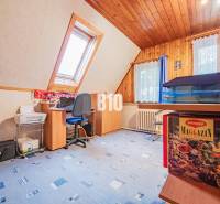POD HRADOM bývanie alebo podnikanie - Podkrovná pracovňa v rodinnom dome s počítačovým stolom a modrým kobercom.