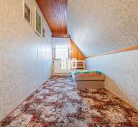 POD HRADOM bývanie alebo podnikanie - Podkrovná izba v rodinnom dome s tapetami a farebným kobercom na podlahe.