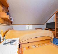 POD HRADOM bývanie alebo podnikanie - Podkrovná spálňa s dreveným nábytkom v rodinnom dome.