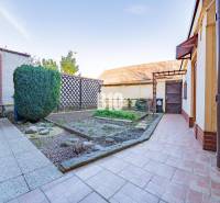 POD HRADOM bývanie alebo podnikanie - Záhrada rodinného domu v Nitre s vydláždeným chodníkom a udržiavaným kríkom.