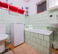 POD HRADOM bývanie alebo podnikanie - Kúpeľňa v rodinnom dome s vaňou, umývadlom a práčkou, s bledozeleným obkladom.