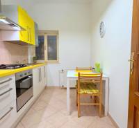 EXKLUZÍVNE, Štýlový 2i byt,, Hviezdoslavovo námestie, Staré.Mesto  - Kuchyňa v 2-izbovom byte s pestrými žltými skrinkami, stôl a stoličky priestor dopĺňajú.