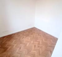 Pekný 3i byt, REKONŠTRUKCIA, KLÍMA, NIVY, Trenčianska ulica - Izba s drevenou podlahou v 3-izbovom byte na ulici Trenčianska.