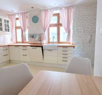 JEDINEČNÝ 2i byt, REKONŠT., 2 X .SAMOST.IZBA, Hviezdoslavovo nám.  - Kuchyňa v 2-izbovom byte s bielymi skrinkami a tehlovou stenou.