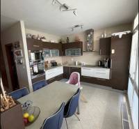 PREDAJ PRIESTRANNÉHO 3 IZB. BYTU NA MUŠKÁTE S GARÁŽOVÝM STÁTIM - Kuchyňa v 3-izbovom byte s tmavým nábytkom a jedálenským stolom.