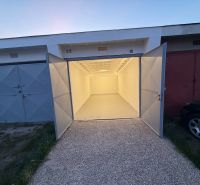 Na predaj kompletne zrekonštruovaná garáž v Trenčíne – ul. Bezručova - Otvorené garáže na Bezručovej ulici v Trenčíne s betónovou podlahou a bielymi stenami.