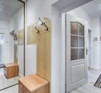 NOVÁ CENA - 5-izbový rodinný dom, dve garáže a krásny pozemok Špačince - Chodba s vešiakovou stenou a zrkadlom v rodinnom dome. Podlaha s dreveným dekorom.