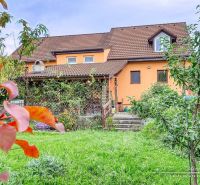 NOVÁ CENA - 5-izbový rodinný dom, dve garáže a krásny pozemok Špačince - Rodinný dom v Špačinciach na Špačinskej ulici s upravenou záhradou a oranžovou fasádou.