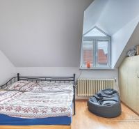 NOVÁ CENA - 5-izbový rodinný dom, dve garáže a krásny pozemok Špačince - Spálňa v rodinnom dome s posteľou, vreckovým kreslom a podlahou s dreveným dekorom.