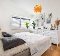 NA PREDAJ Krásny domček v Ivánke pri Nitre - Svetlá spálňa s bielym zariadením, podlaha s dreveným dekorom v rodinnom dome.