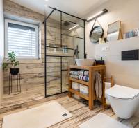 NA PREDAJ Krásny domček v Ivánke pri Nitre - Kúpeľňa v rodinnom dome s podlahou s dreveným dekorom a sprchovým kútom.