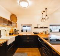 NA PREDAJ Krásny domček v Ivánke pri Nitre - Kuchyňa v rodinnom dome s podlahou s dreveným dekorom a keramickým drezom.