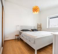 NA PREDAJ Krásny domček v Ivánke pri Nitre - Spálňa v rodinnom dome s bielym nábytkom a podlahou s dreveným dekorom.