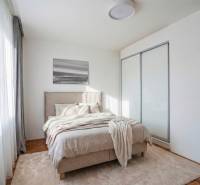 NA PREDAJ štýlový byt v centre Nitry  - Spálňa v 3-izbovom byte s pohodlnou posteľou, presklenými dverami a podlahou s dreveným dekorom.