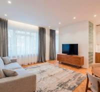 NA PREDAJ štýlový byt v centre Nitry  - Obývačka so sedačkou, televízorom a podlahou s dreveným dekorom v 3-izbovom byte.