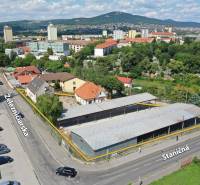NA PRENÁJOM skladové priestory - areál v centre Nitry - Letecký pohľad na Železničiarsku ulicu v Nitre, Sklady a haly, okolité budovy a zeleň.