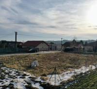 NA PREDAJ Stavebný pozemok v obci Golianovo - Pozemky - bývanie v Golianove, dedinské domy, cesta a zasnežená krajina pod oblohou.
