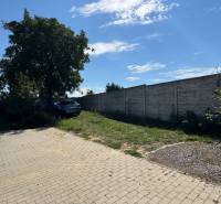 NA PREDAJ Radový rodinný dom v obci Malý Lapáš - Dvor rodinného domu v Malom Lapáši so spevnenou plochou a zeleňou pri múre.