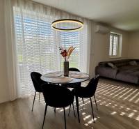 NA PREDAJ 4 izbový rodinný dom Štitáre NITRA - Jedálenský stôl s riadom a dekoráciou, pohovka, podlaha s dreveným dekorom.