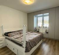 NA PREDAJ 4 izbový rodinný dom Štitáre NITRA - Spálňa v rodinnom dome so vstavanými skriňami a podlahou s dreveným dekorom.