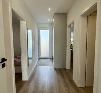 NA PREDAJ 4 izbový rodinný dom Štitáre NITRA - Chodba v rodinnom dome s podlahou s dreveným dekorom a bielymi stenami.