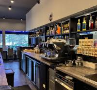 ODSTÚPENIE Gastro prevádzky na Námestí v Nitre - Interiér gastro priestoru s barovým pultom, vybavením a výhľadom vonku.