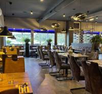 ODSTÚPENIE Gastro prevádzky na Námestí v Nitre - Reštaurácia s podlahou s dreveným dekorom, štýlovým osvetlením a dekoráciami v gastro priestoroch.