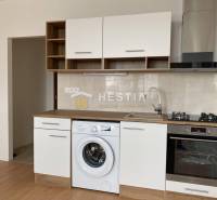 NA PRENÁJOM zrekonštruovaný 1-IZB.BYT, Štefánikova ul., Senica - Kuchyňa v 1-izbovom byte s práčkou a podlahou s dreveným dekorom.
